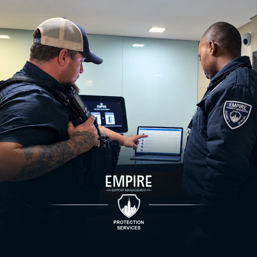 Two Empire officers reviewing the EMR reporting system on a laptop at a building reception desk