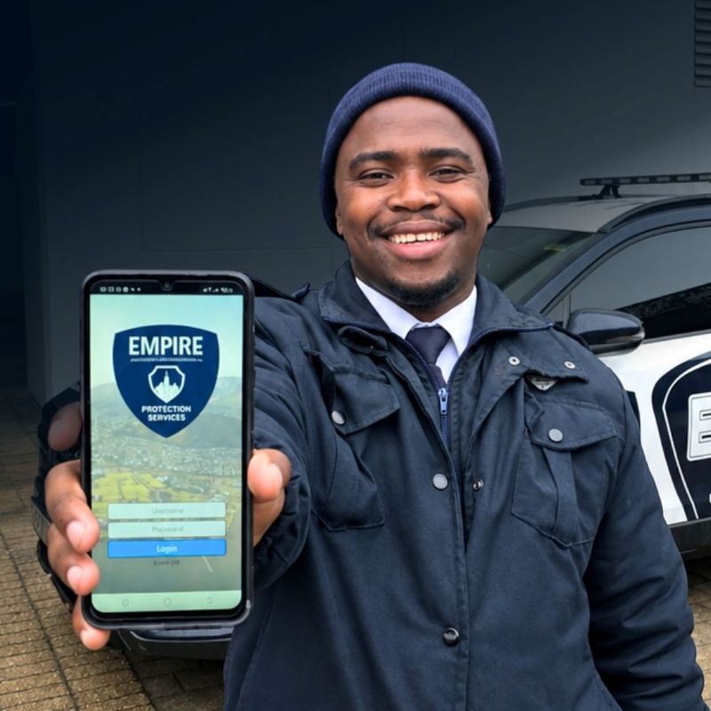 Smiling Empire officer holding up a phone showing the EMR app login screen