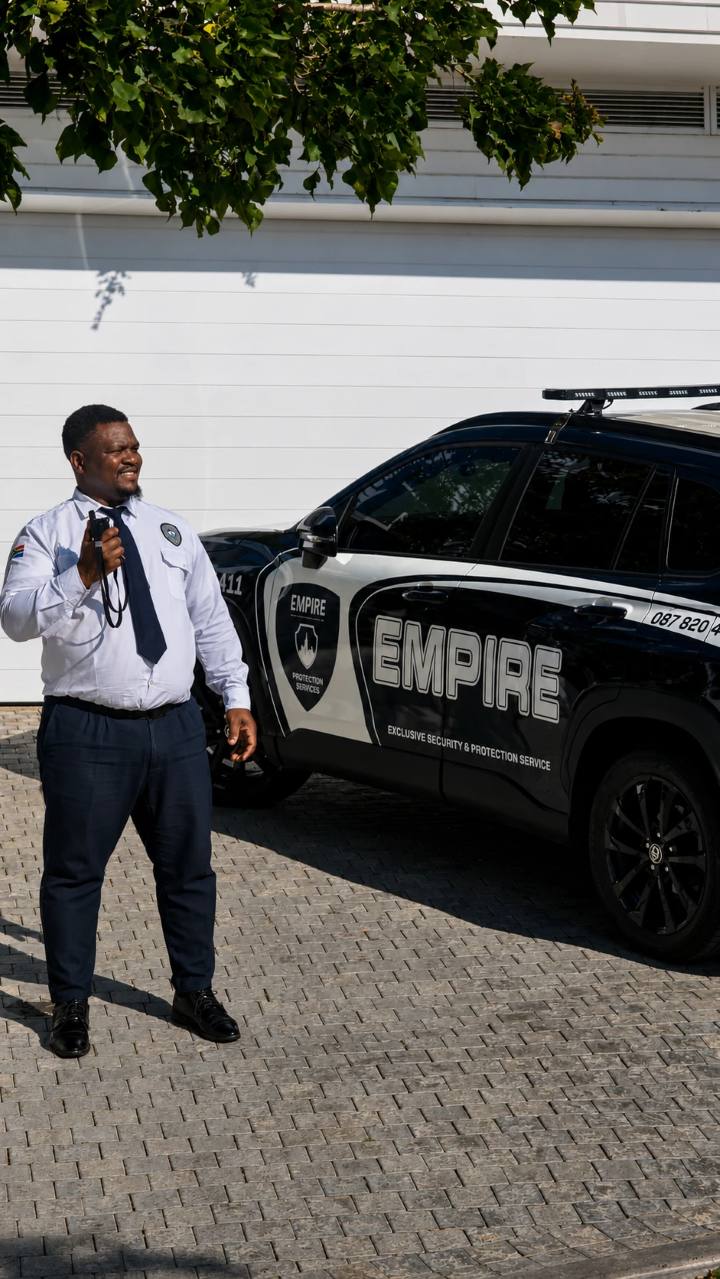 Empire officer with a radio beside a branded Empire patrol vehicle