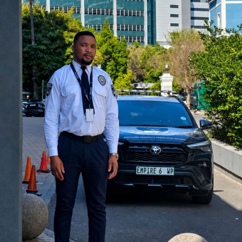 Empire officer standing at a site entrance in front of an Empire vehicle